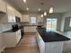Bright kitchen with white cabinets, granite counters, stainless appliances, and island at 60 Cordoba Dr, Franklinton, NC 27525