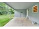 View of the back porch with concrete floor and two entry doors; it overlooks a large green, grassy yard at 621 Shepard School Rd, Zebulon, NC 27597