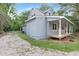 Side view of a light blue two-story home with a gravel driveway and covered porch at 621 Shepard School Rd, Zebulon, NC 27597
