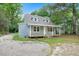 Well-maintained two-story home with a classic design, front porch, and a gravel front yard at 621 Shepard School Rd, Zebulon, NC 27597