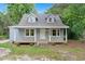 Exterior shot of the house displaying a cozy porch and dormer windows at 621 Shepard School Rd, Zebulon, NC 27597