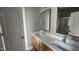 Modern bathroom with double sinks, wood cabinets, and a well-lit mirror at 65 Leisure Ln, Louisburg, NC 27549