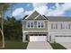 Two-story townhome with green siding, stone accents, and a two-car garage at 7125 Hubner Pl # 24, Cary, NC 27519