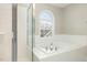 Bright bathroom showcasing a garden tub with chrome fixtures, tiled walls, and a glass-enclosed shower at 749 Swan Neck Ln, Raleigh, NC 27615