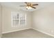 Neutral carpeted bedroom featuring a bright window and a ceiling fan at 749 Swan Neck Ln, Raleigh, NC 27615