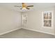 Neutral carpeted bedroom with natural light streaming from two windows with blinds, and a ceiling fan at 749 Swan Neck Ln, Raleigh, NC 27615