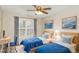 Well-lit bedroom featuring twin beds dressed in blue, a bright window, desk and blue accent chair at 749 Swan Neck Ln, Raleigh, NC 27615