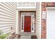Inviting red front door with sidelights and transom window, framed by brick accents at 749 Swan Neck Ln, Raleigh, NC 27615