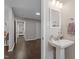 Small bathroom with pedestal sink, mirror, and white vanity at 816 Peyton St, Raleigh, NC 27610