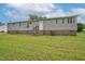 Mobile home exterior view showcasing a large yard and brick foundation at 95 Old Barn Ct, Rocky Mount, NC 27801