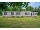 Tan mobile home with black shutters and a spacious lawn at 95 Old Barn Ct, Rocky Mount, NC 27801