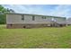 Single-wide mobile home with brick skirting and a spacious backyard at 95 Old Barn Ct, Rocky Mount, NC 27801