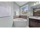 Corner bathtub with a window view, complemented by stylish fixtures and natural light at 101 Pointe Park Cir, Holly Springs, NC 27540