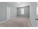 This empty bedroom features neutral walls and carpet, plus a single window for natural light at 101 Pointe Park Cir, Holly Springs, NC 27540