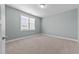 This bright bedroom has neutral carpet, light-blue walls, and a window for natural light at 101 Pointe Park Cir, Holly Springs, NC 27540