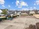 View of the neighborhood homes with landscaped yards, a playground, and concrete recreational area at 101 Pointe Park Cir, Holly Springs, NC 27540