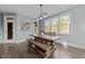 Bright dining room with a large wooden table, bench seating, modern light fixture, and plenty of natural light at 101 Pointe Park Cir, Holly Springs, NC 27540