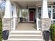 Cozy front porch with stone pillars, a bench, and a hanging lantern, perfect for relaxing at 101 Pointe Park Cir, Holly Springs, NC 27540