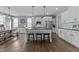 Spacious kitchen with white cabinets, black countertops, stainless steel appliances, and a large island with barstool seating at 101 Pointe Park Cir, Holly Springs, NC 27540