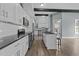 Modern kitchen with black countertops, stainless steel appliances, and a cozy breakfast bar at 101 Pointe Park Cir, Holly Springs, NC 27540