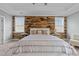 Serene main bedroom featuring a wood accent wall, neutral tones, and a ceiling fan at 101 Pointe Park Cir, Holly Springs, NC 27540