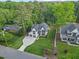 Aerial view of a landscaped home with a long driveway and a yard surrounded by lush trees at 1304 Ivy Ln, Raleigh, NC 27609