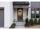 Front entry with a wooden door, lighting, and planters at 1304 Ivy Ln, Raleigh, NC 27609