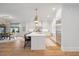 Open concept kitchen with white cabinets, island seating, and hardwood floors at 1304 Ivy Ln, Raleigh, NC 27609