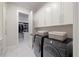 Bright laundry room with washer, dryer, and extra cabinets at 1304 Ivy Ln, Raleigh, NC 27609