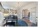 Sunlit music room with a grand piano and hardwood floors at 1304 Ivy Ln, Raleigh, NC 27609
