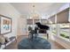 Bright music room featuring a grand piano, hardwood floors, and large windows at 1304 Ivy Ln, Raleigh, NC 27609