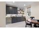 Basement wet bar with dark cabinetry, beverage fridge and game table at 1304 Ivy Ln, Raleigh, NC 27609
