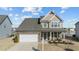 Two-story house with a stone facade, two-car garage, and landscaped yard at 2120 Blue Iris Way, Zebulon, NC 27597