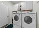 Laundry room with Samsung washer and dryer and upper cabinets at 2120 Blue Iris Way, Zebulon, NC 27597