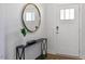 Bright entryway with a round mirror, console table, and hardwood floors at 2332 Sugar Cone Way, Fuquay Varina, NC 27526