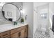 Modern bathroom with patterned tile floor, large mirror, and updated vanity at 257 Rawhide Dr, Louisburg, NC 27549