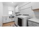 Bright laundry room with white cabinets, farmhouse sink, and washer/dryer at 257 Rawhide Dr, Louisburg, NC 27549