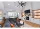 Open-concept living room with a stone fireplace, sectional sofa, and access to a deck at 257 Rawhide Dr, Louisburg, NC 27549