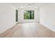 Bright bedroom featuring hardwood floors and a large window with a lush green view at 29 Enterprise St # 107, Raleigh, NC 27607