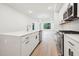 Open kitchen area with white cabinets, stainless appliances and island with sink at 29 Enterprise St # 107, Raleigh, NC 27607