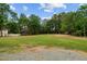 Large grassy backyard with mature trees and gravel pathway at 309 Hawkins Ave, Sanford, NC 27330