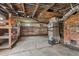 Unfinished basement with exposed brick, HVAC unit, and shelving at 309 Hawkins Ave, Sanford, NC 27330