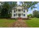 Two-story white house with blue shutters, wraparound porch, and stone pathway at 309 Hawkins Ave, Sanford, NC 27330