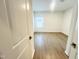 Bright, empty bedroom features wood-look floors, white walls, and a window with natural light at 3284 Roundly Rd # 16, New Hill, NC 27562