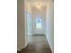 Bright hallway with wood-look flooring and white walls leads to a glass-paneled front door at 3284 Roundly Rd # 16, New Hill, NC 27562