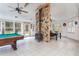 Game room features a stone fireplace, pool table, and plenty of natural light at 6328 Bissette Rd, Wendell, NC 27591