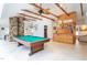 Game room features a pool table, built-in bar, and wood-beamed ceiling at 6328 Bissette Rd, Wendell, NC 27591