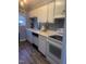 Bright kitchen with white cabinets, laminate flooring, and appliances at 6369 New Market Way, Raleigh, NC 27615
