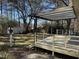 Backyard deck with railings and a partial covering, overlooking the lawn and trees at 7317 Bentley Wood Ln, Raleigh, NC 27616