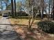 Cozy single-story home with a brick facade and lush green lawn with mature trees at 7317 Bentley Wood Ln, Raleigh, NC 27616